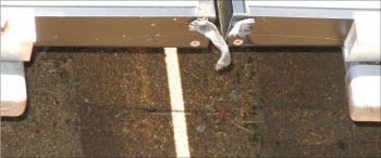 Photo 5. Improper use of module bonding screw and copper in braid touching aluminum.