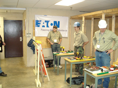 Photo 2. Students Arrive Prepared. Each student that participated in the Residential Wiring or Motor Control portions of the program had a cubicle with a desk where they arranged their tools. Safety was a key aspect and each student was reviewed for clothing which included eye protection, hard hats and proper clothing.