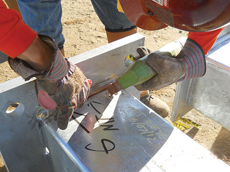 Photo 17. Inspector using magnetic particle testing to identify defective welds