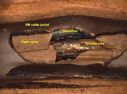 This image shows an arcing area of a damaged, then aged, NM cable sample, simulating the effect of cable aging after it was damaged during installation. The image shows that there is an area of electric arc.