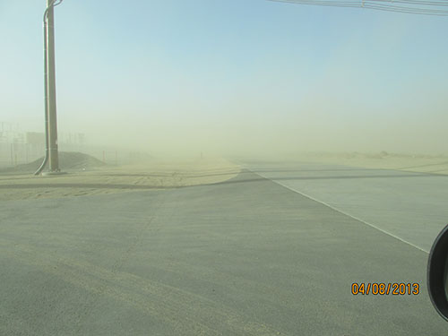 Photo 1B. Dust migrating off the site creates limited sight distance for drivers. The speed limit along this highway is 55 MPH.