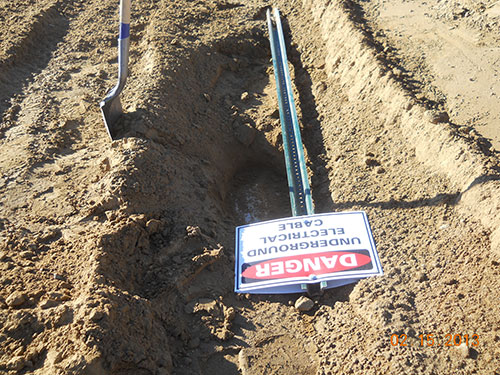 Photo 6C. That’s my shovel in the foreground. I found the sign under a few inches of dirt. This sign is resting on the concrete duct bank.