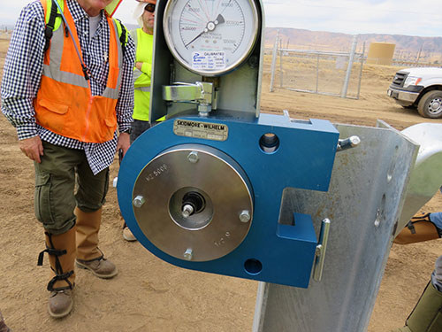 Photo 9E. Special inspectors using a skidmore to verify the clamping force of a Huck fastener used in place of an A-325. Additional testing was required.