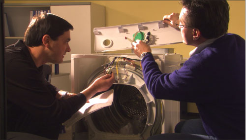 Initial Review. A UL product engineer and reviewing engineer evaluate the construction of a clothes dryer during their preliminary review of the product for compliance with the safety standard.