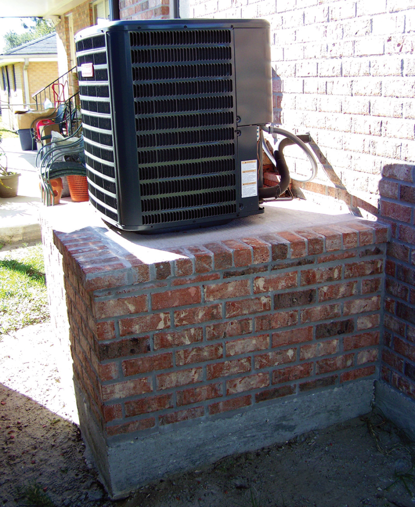 Photo 1. Air conditioning compressor elevated on a pedestal.