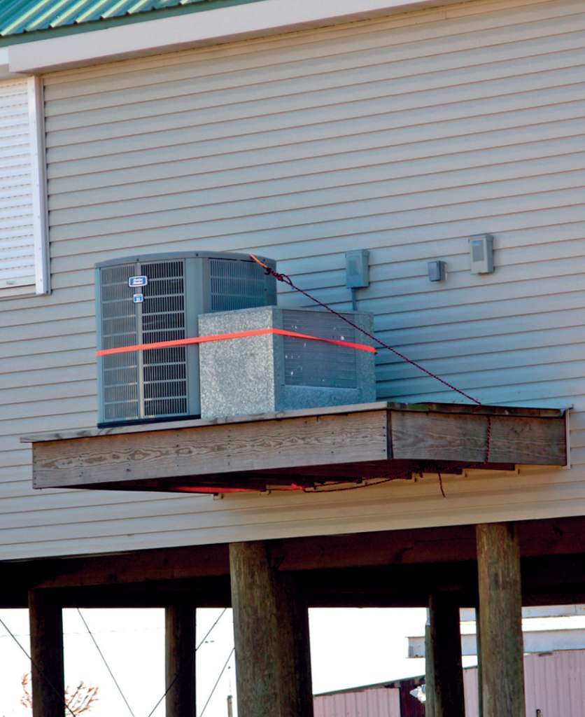 Photo 2. Air conditioning compressor elevated on a cantilevered platform.