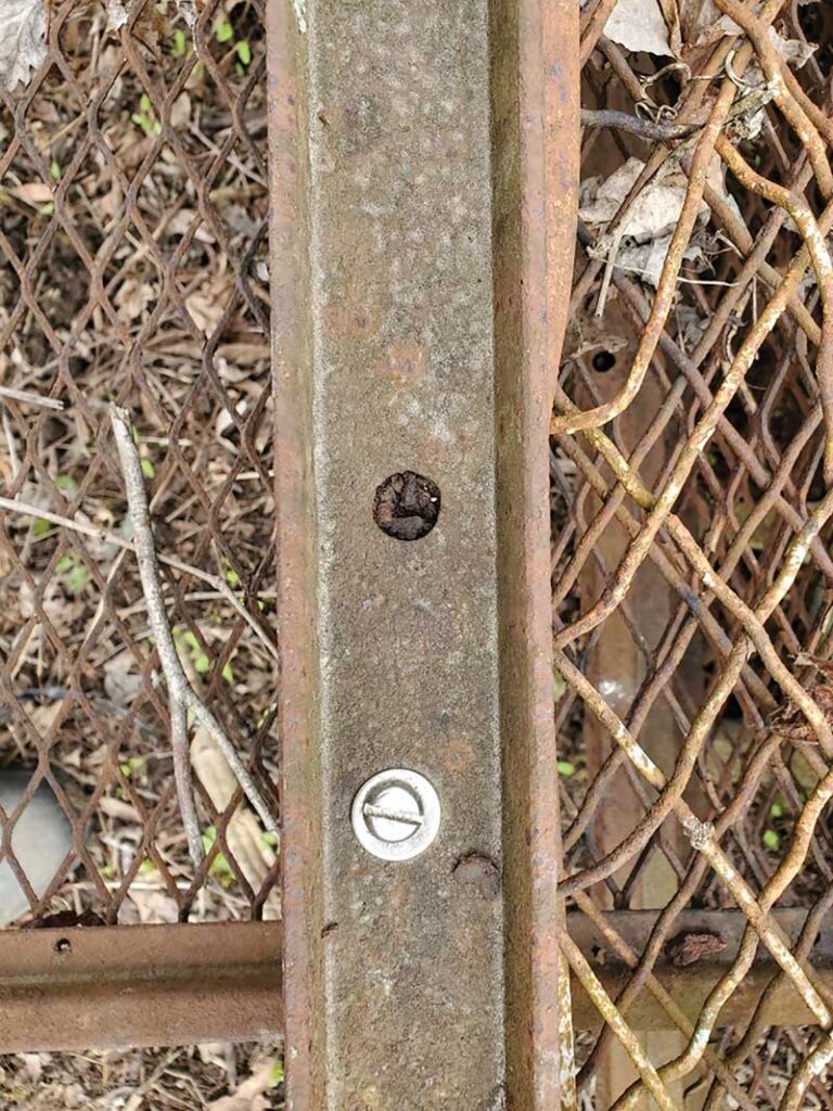 Photo 1. Corroded steel frame with intact stainless-steel screw