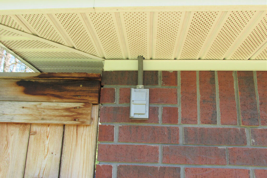 Photo 1a. A determination by the AHJ has determined this receptacle outlet located beneath the soffit as a damp location, thus allowing a flip type cover.