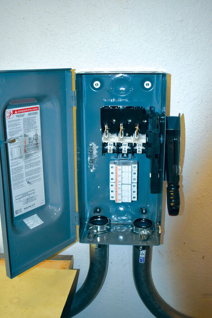 Photo 6. Workstation interface disconnect to 380 VDC bus.  Midget fuse holders rated at 30A are located below the witch mechanism. Courtesy of John Wiles