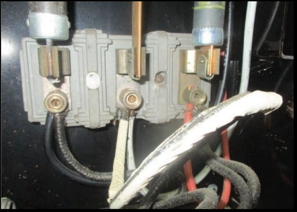 Figure 4. A fuse replaced with a metal rod, as an example of a code violation. In addition, two conductors for termination is a violation of the NEC.