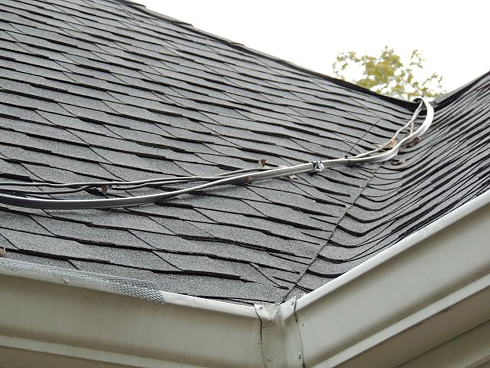 Photo 4. Unsecured conductors across the roof may be damaged by rain, wind, snow, or ice. Courtesy of John Wiles